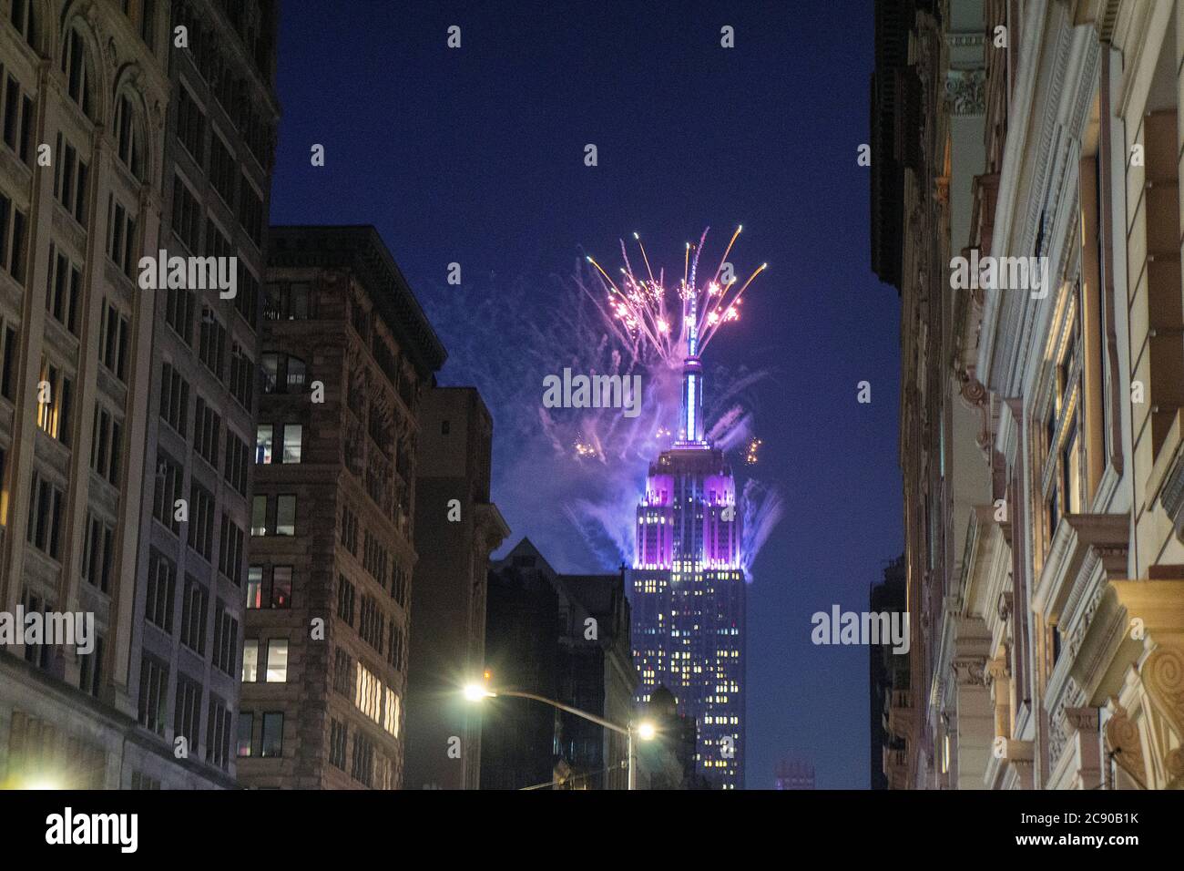 Empire State Building mit blauem Feuerwerk bei Nacht, Blick von der Lower Fifth Avenue, New York City, New York, USA Stockfoto