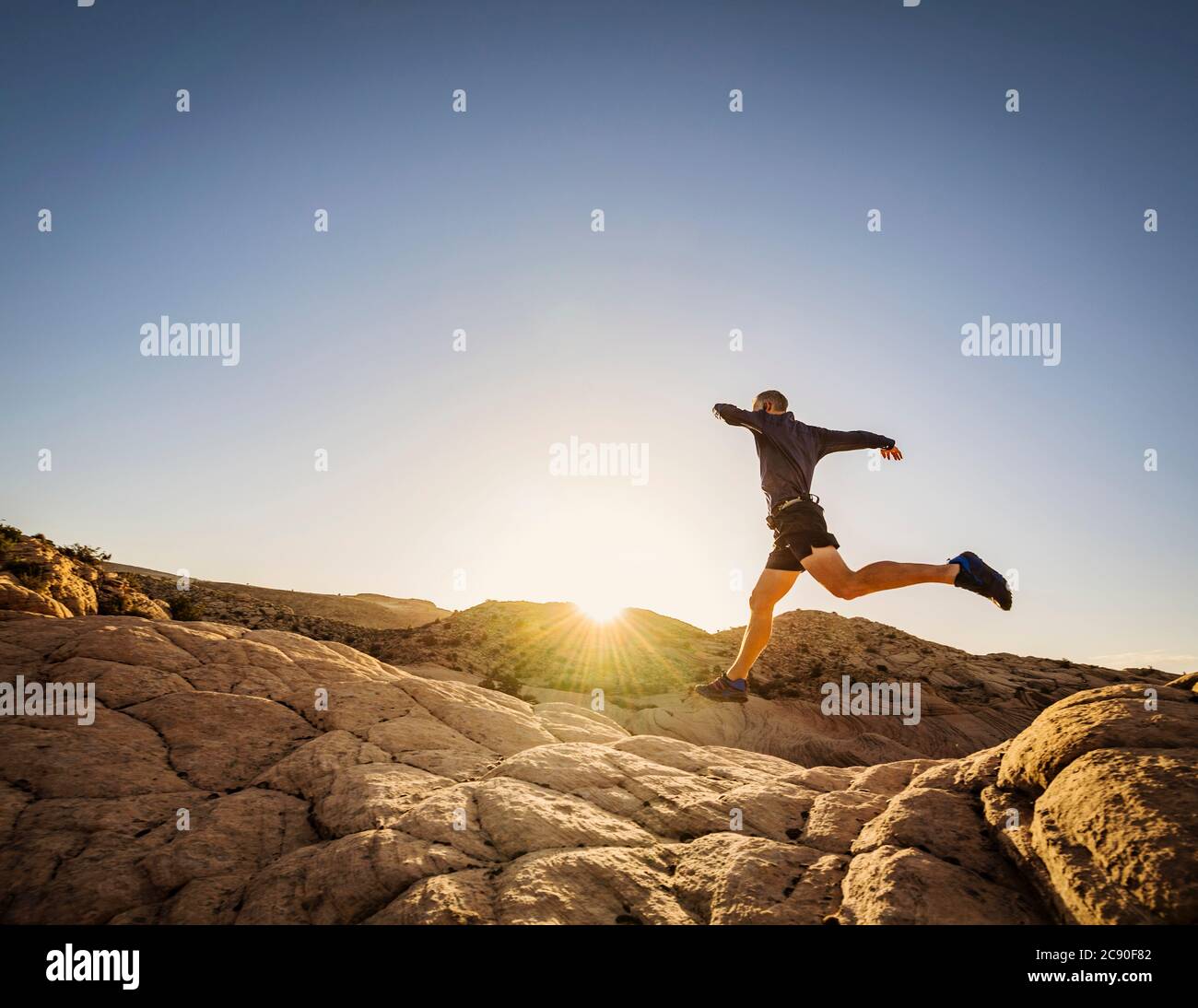 USA, Utah, St. George, man springt beim Laufen in felsiger Landschaft Stockfoto