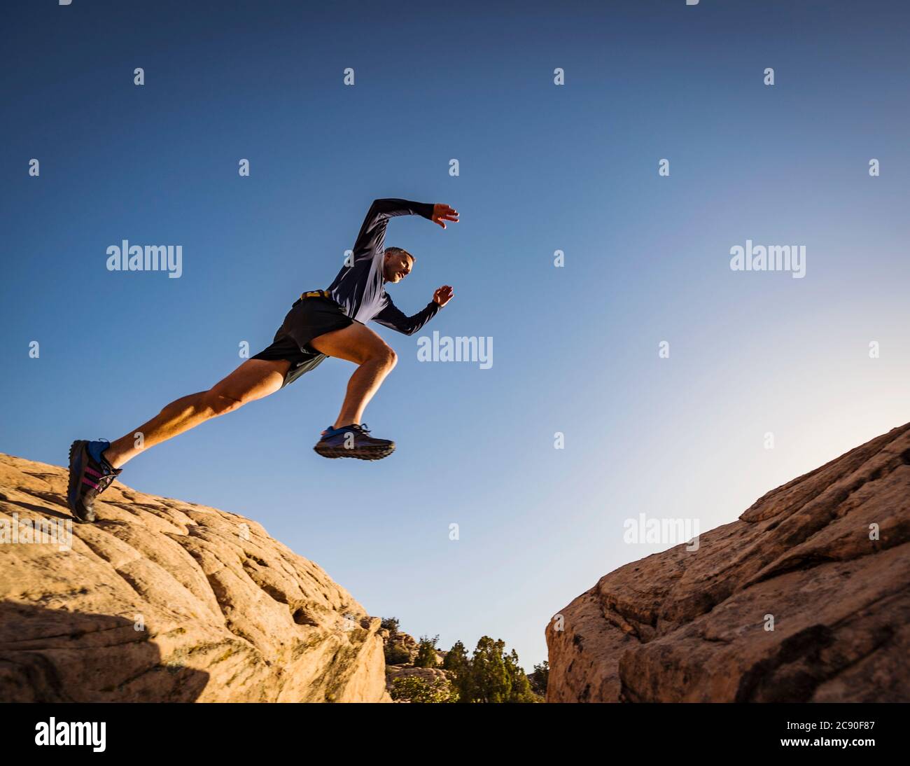 USA, Utah, St. George, man springt über Felsen und läuft in erodierter Landschaft Stockfoto