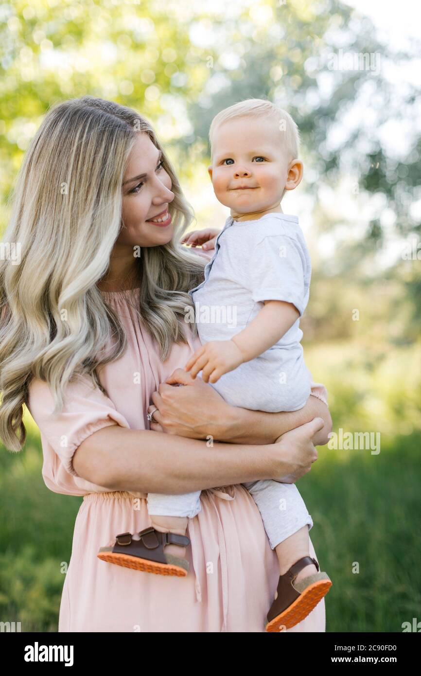 Außenportrait von lächelnder Mutter und Baby Sohn Stockfoto