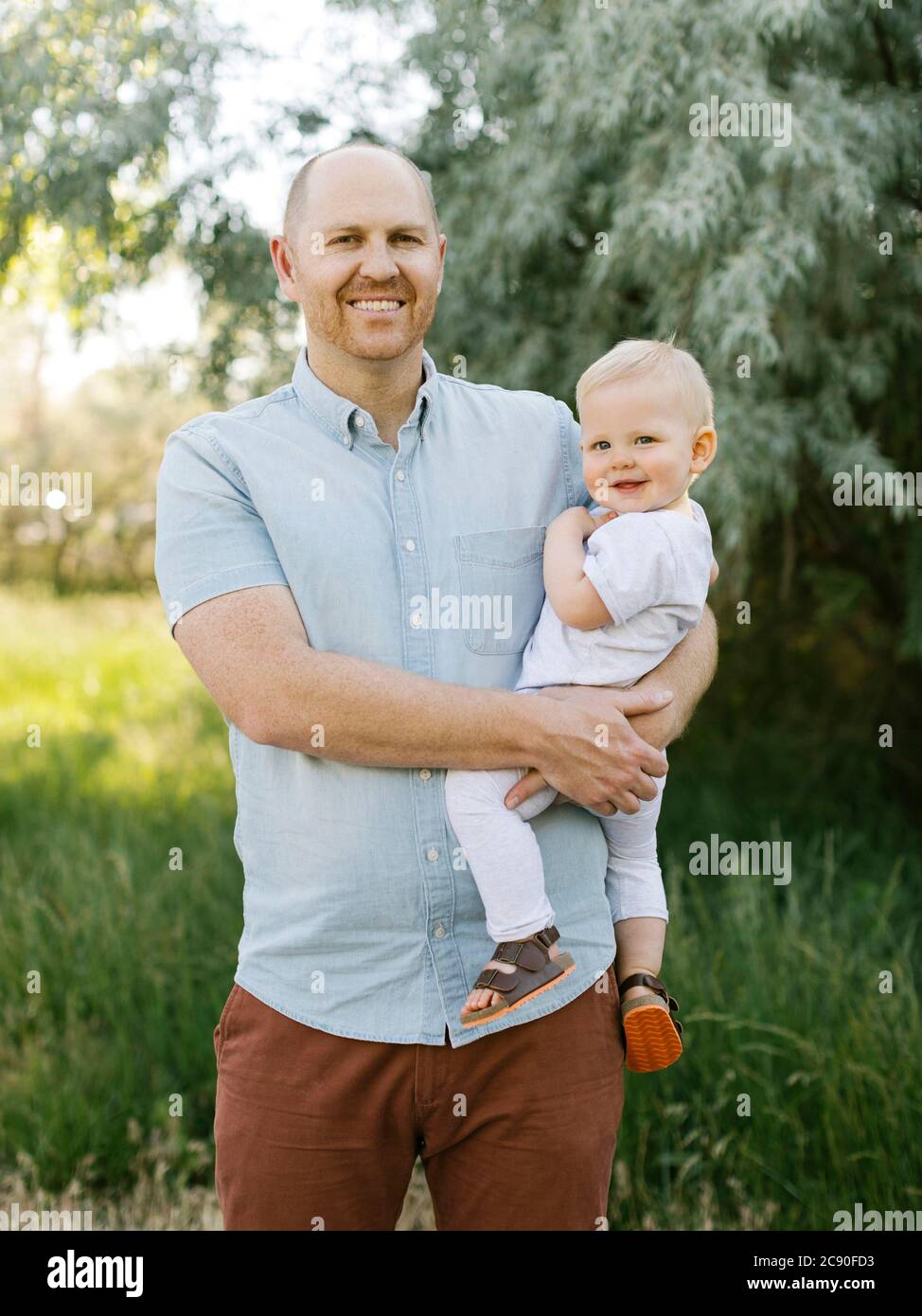 Im Freien Porträt von lächelndem Vater mit Baby Sohn Stockfoto