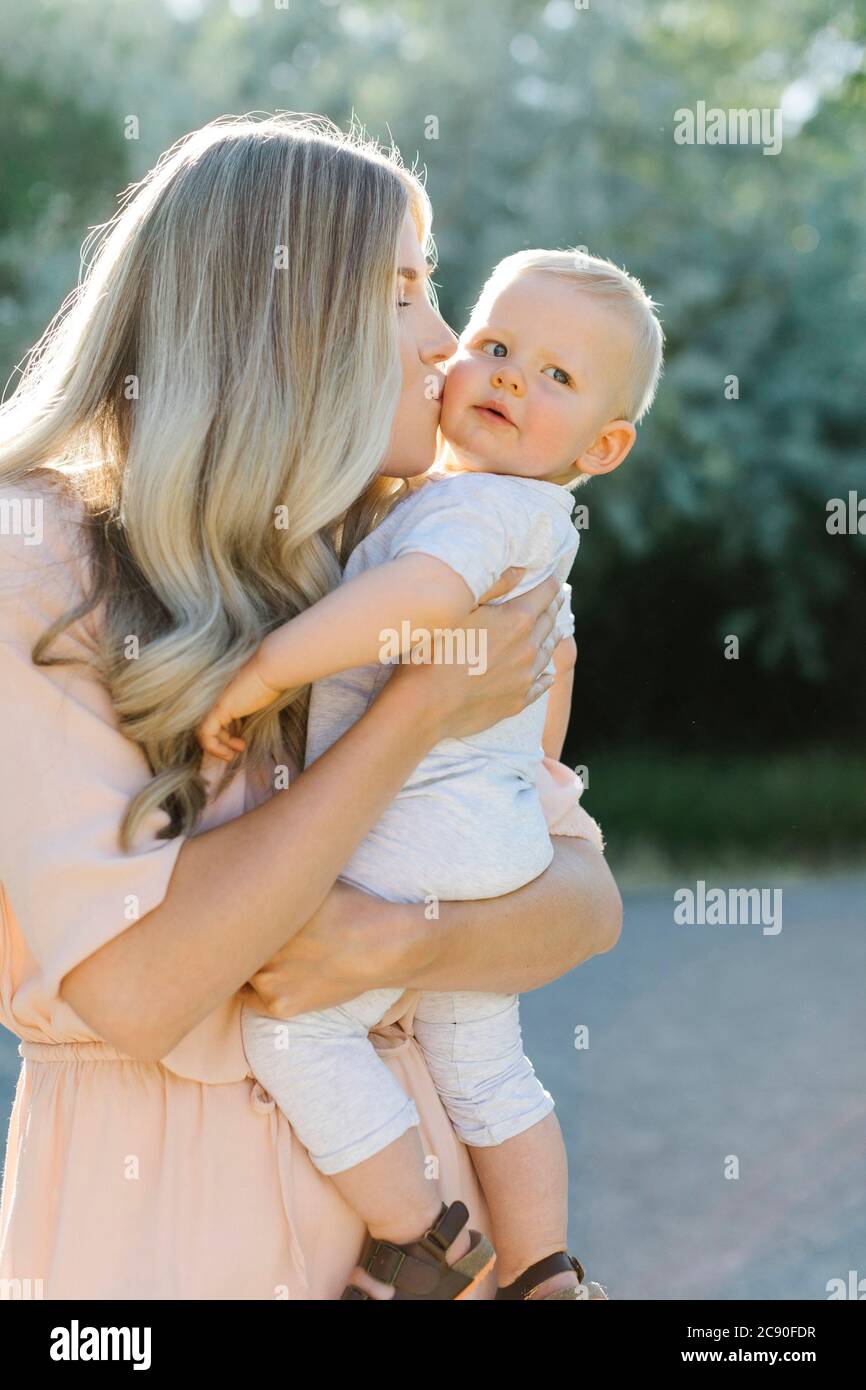 Mutter küsst Baby Sohn im Freien Stockfoto