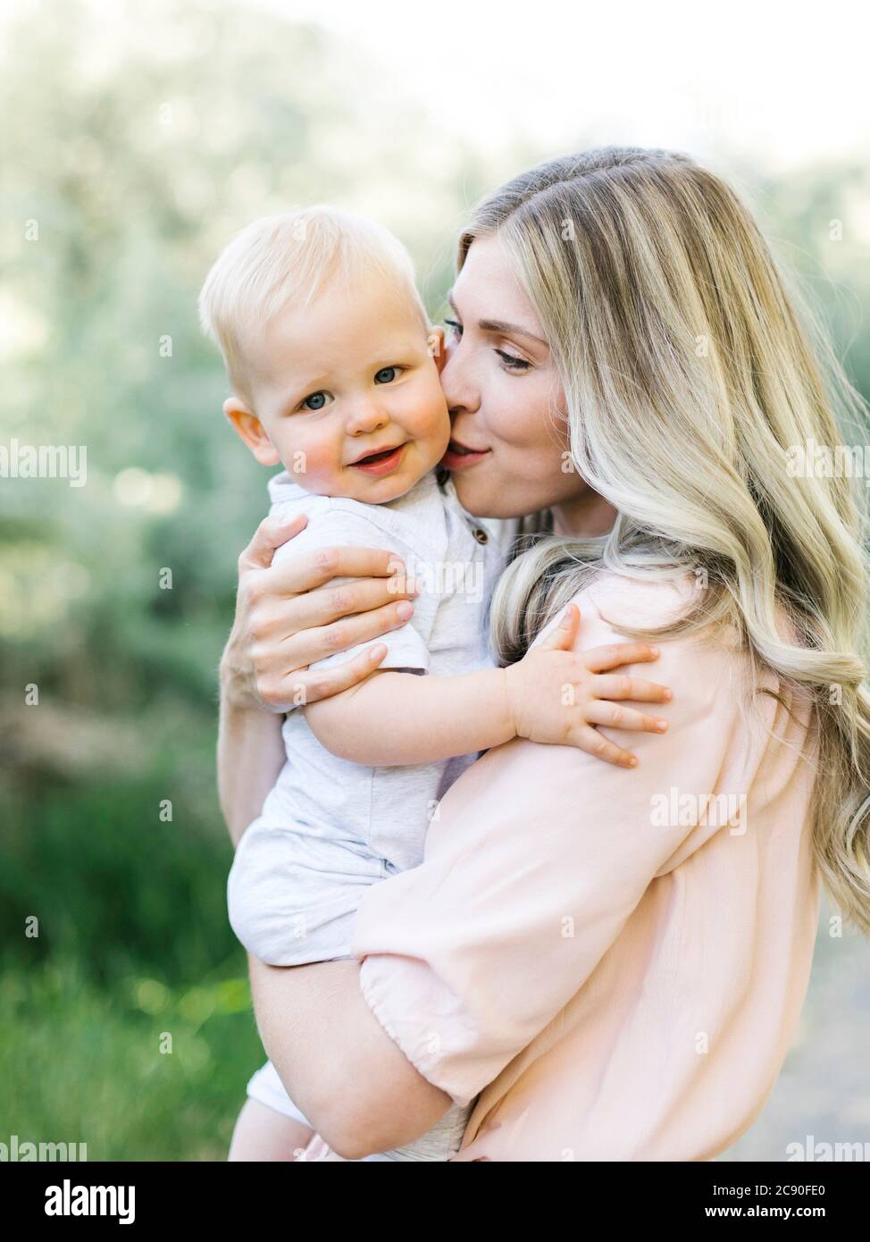 Mutter umarmt Baby Sohn im Freien Stockfoto