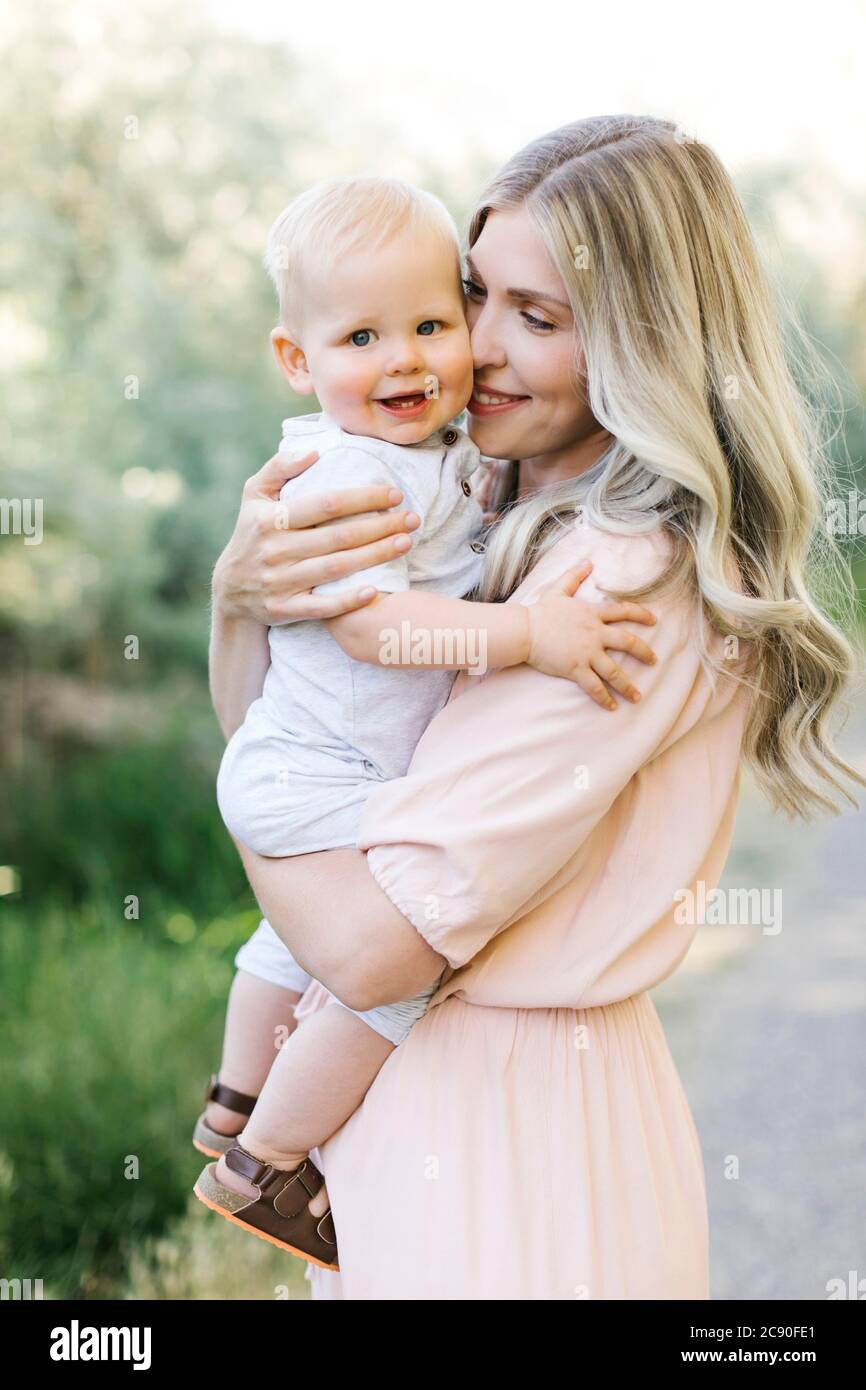 Mutter umarmt Baby Sohn im Freien Stockfoto