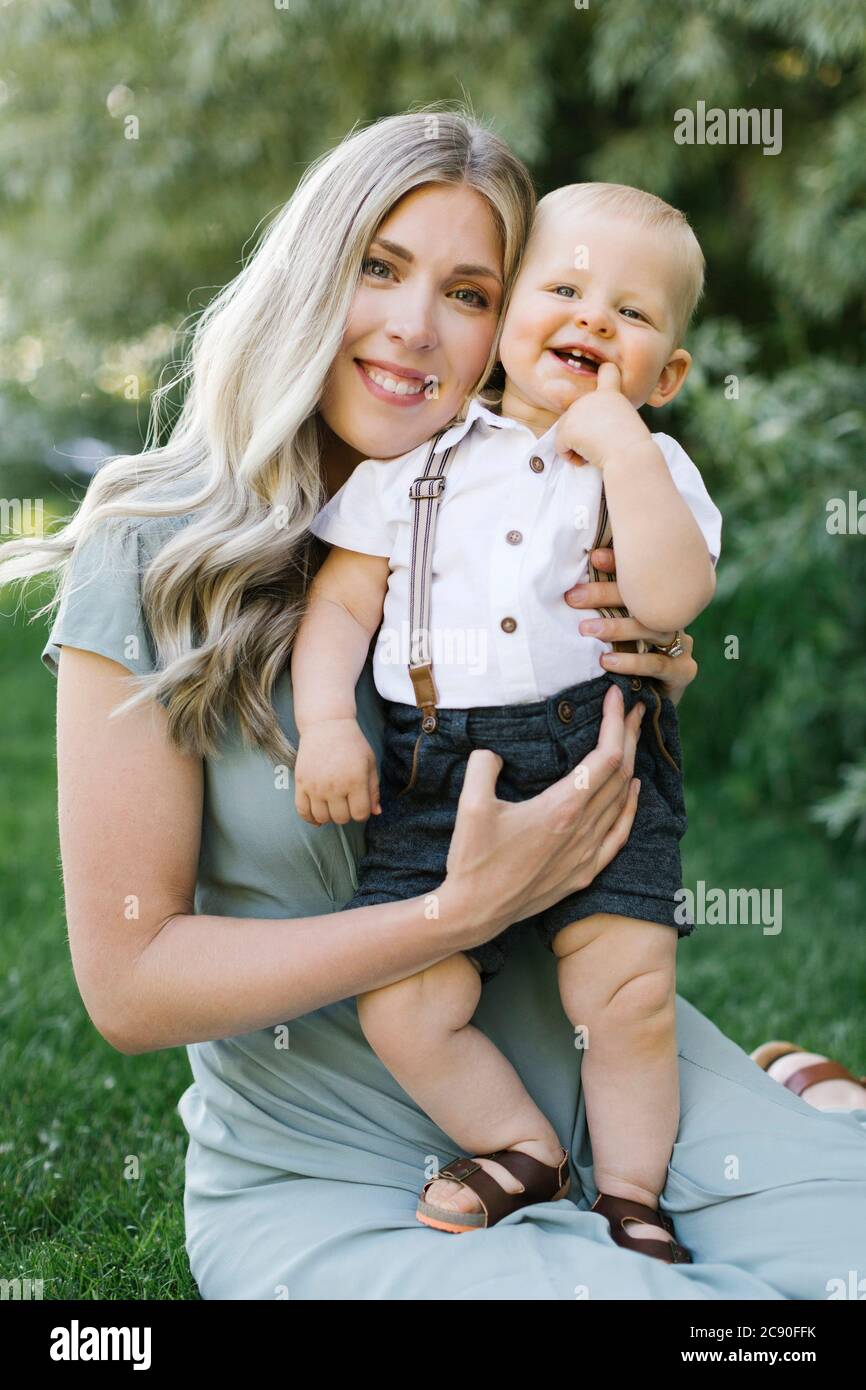 Außenportrait der lächelnden Mutter mit Baby-Sohn Stockfoto