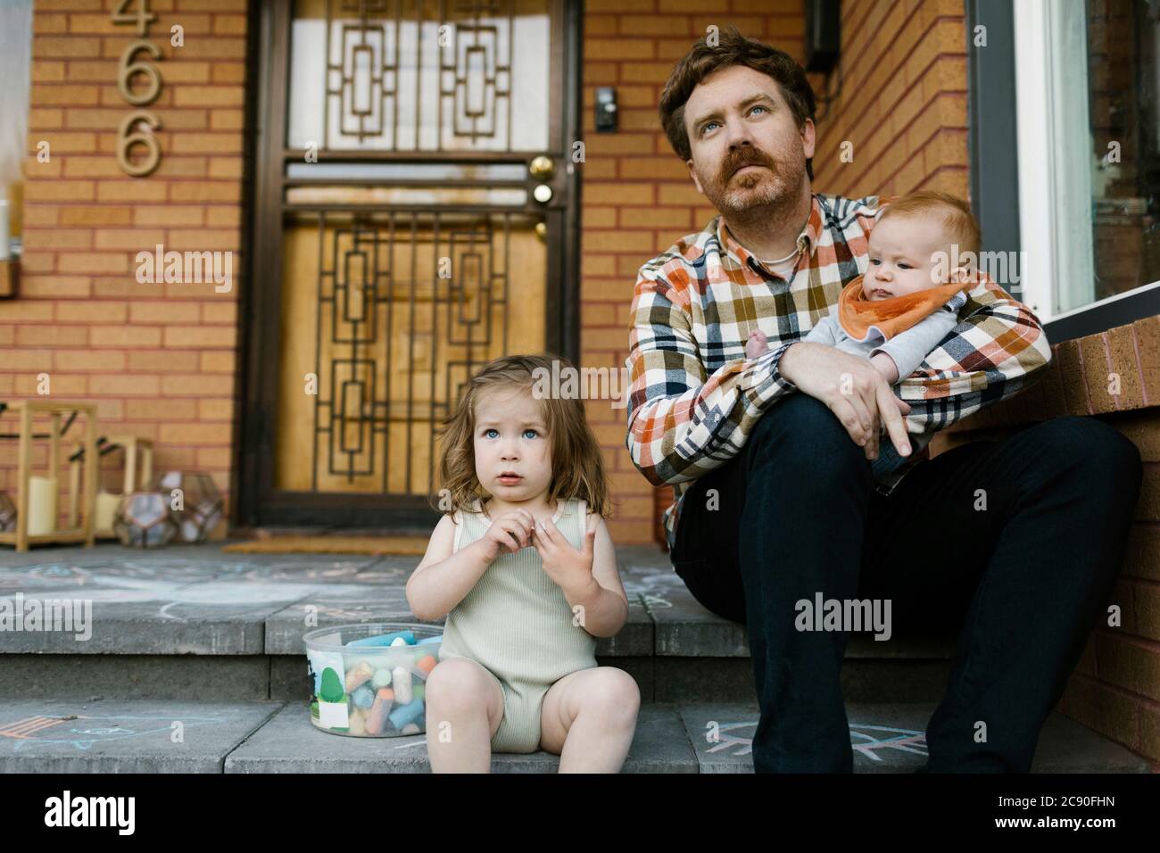 Vater mit Kindern auf der Veranda sitzen Stockfoto