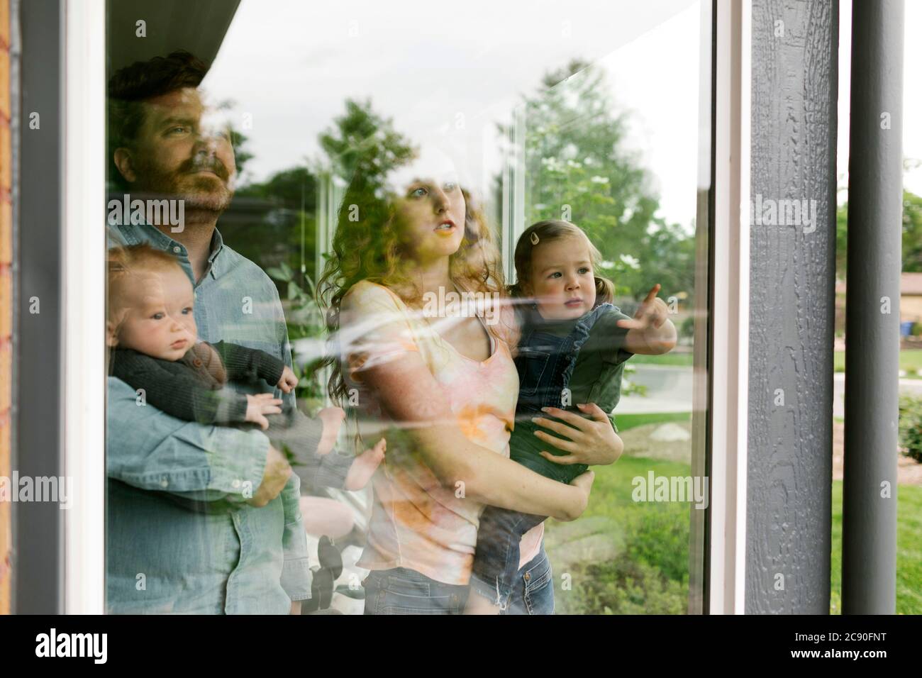USA, Utah, Salt Lake City, Familie mit Kindern (6-11 Monate, 2-3) beim Blick durch das Fenster Stockfoto
