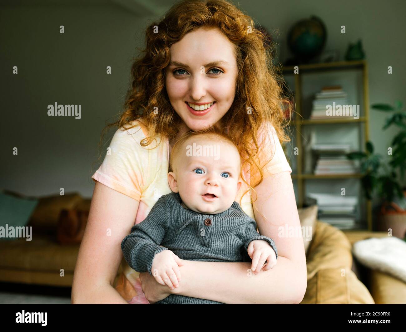 Porträt einer Frau, die einen kleinen Sohn hält (6-11 Monate) Stockfoto