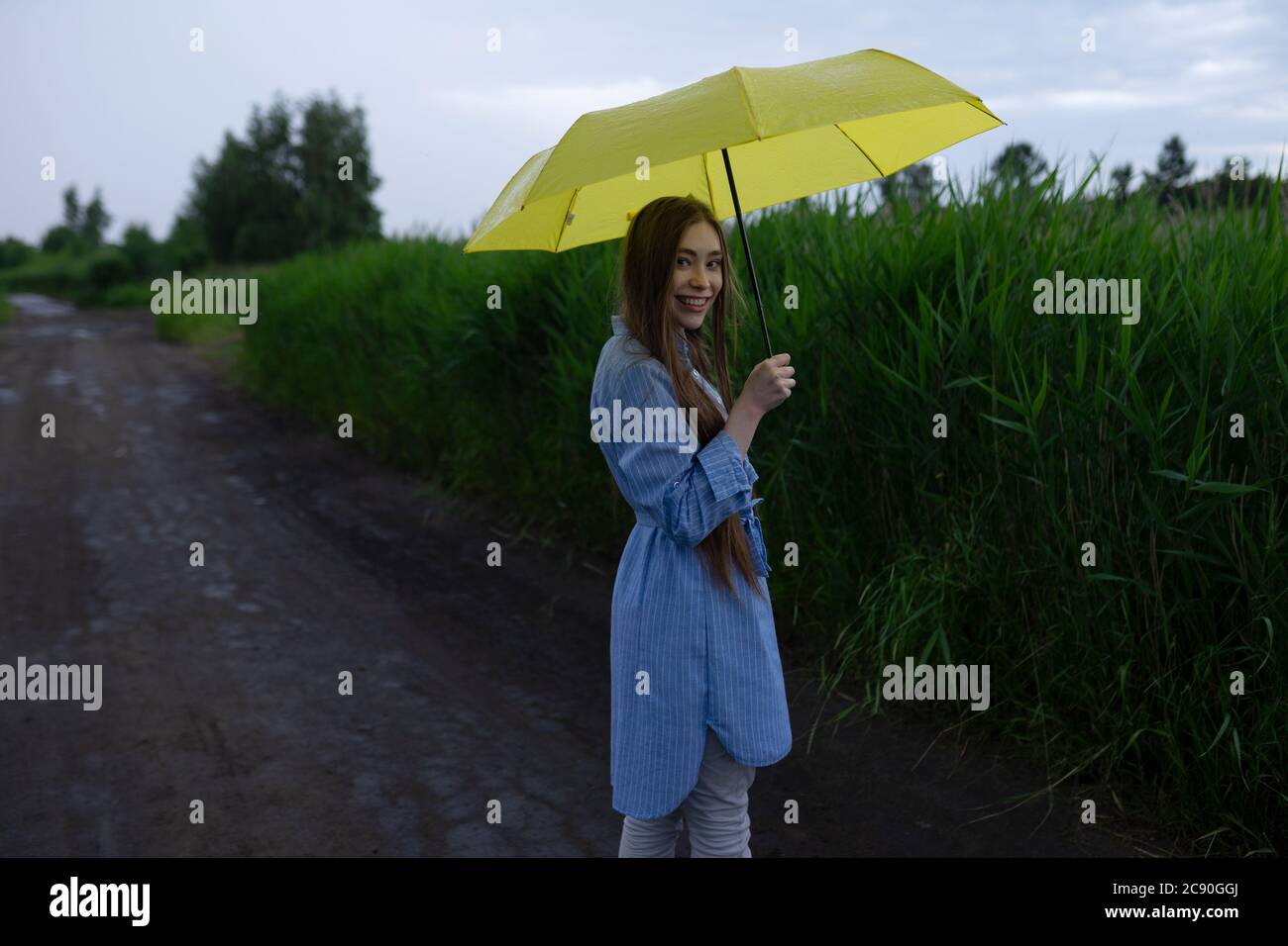 Russland, Omsk, Porträt einer jungen Frau mit Regenschirm auf Feldweg Stockfoto