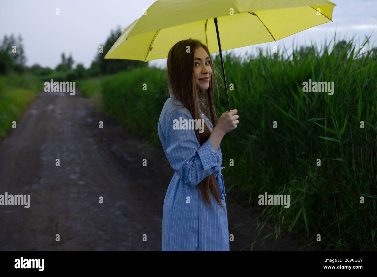 Russland, Omsk, Porträt einer jungen Frau mit Regenschirm auf Feldweg Stockfoto