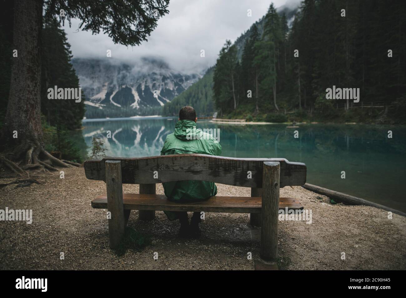 Italien, auf der Bank sitzender Mann, der Pragser Wildsee anschaut Stockfoto