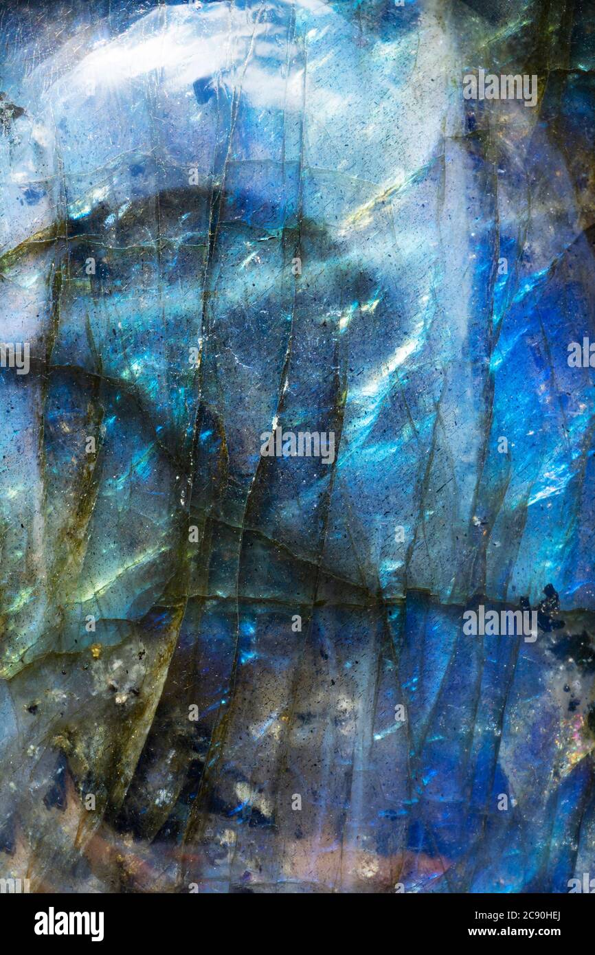Makro-Foto von einem bunten blauen Labradorit Stein mit einem surrealen Berglandschaft Blick darauf. Die Beleuchtung bringt die irisierende mineralische Textur hervor. Stockfoto