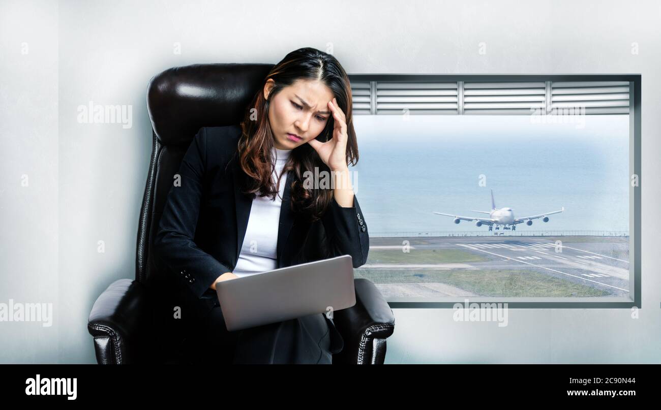 asiatische Geschäftsfrau Sorge der Arbeit auf Laptop im Fluggeschäft in Coronavirus Pandemie, weil verlorene Kunden und sperren Land und stoppen Transporta Stockfoto