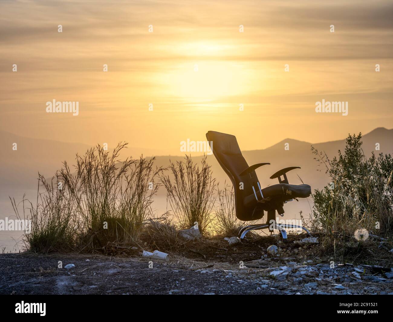 Ein verlassener Bürostuhl in einer Sonnenuntergangslandschaft. Stockfoto