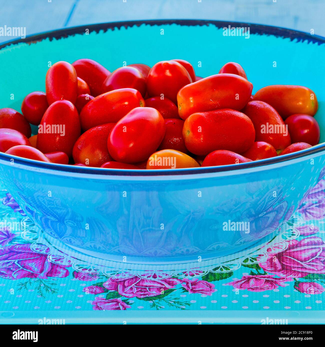 Kirschtomaten. Saftige rote Kirschtomaten in einer türkisfarbenen Salatschüssel. Makroaufnahme. Stockbild Stockfoto