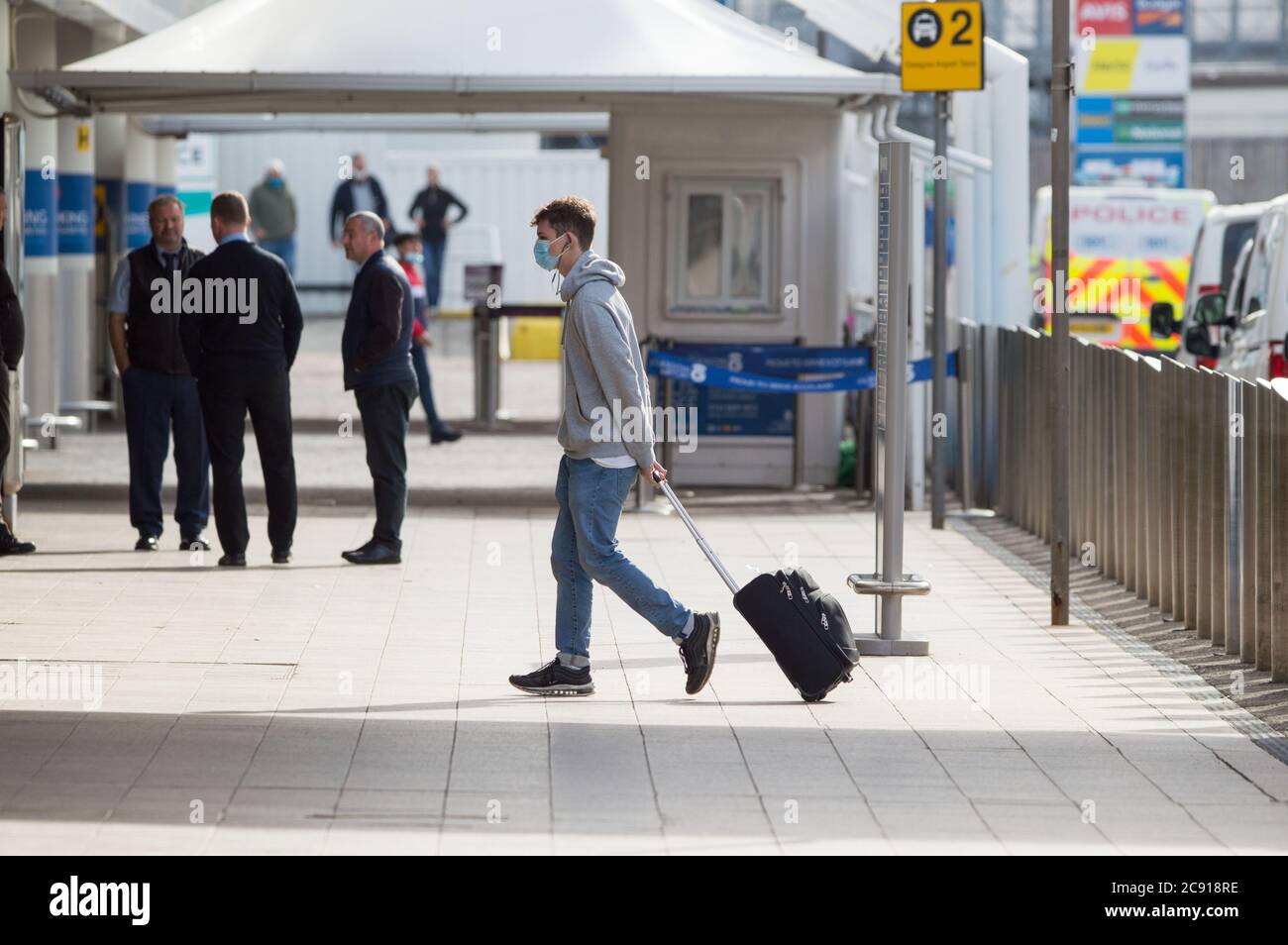 Glasgow, Schottland, Großbritannien. Juli 2020. Im Bild: Passagiere, die den Flughafen Glasgow nutzen, sehen, wie sie ihr Gepäck mit Gesichtsmasken tragen. Heute storniert Jet2 Holidays alle Flüge nach Teneriffa, Fuerteventura, Gran Canaria, Lanzarote, Mallorca, Menorca und Ibiza, nachdem das Auswärtige Amt von nicht-wesentlichen Reisen zu den Inseln abgeraten hat. Jet2-Flugzeuge stehen jetzt auf dem Asphalt in Glasgow. Jet2 hat Passagieren geraten, nicht zu schottischen Flughäfen zu reisen, da ihre Flüge annulliert wurden. Quelle: Colin Fisher/Alamy Live News Stockfoto