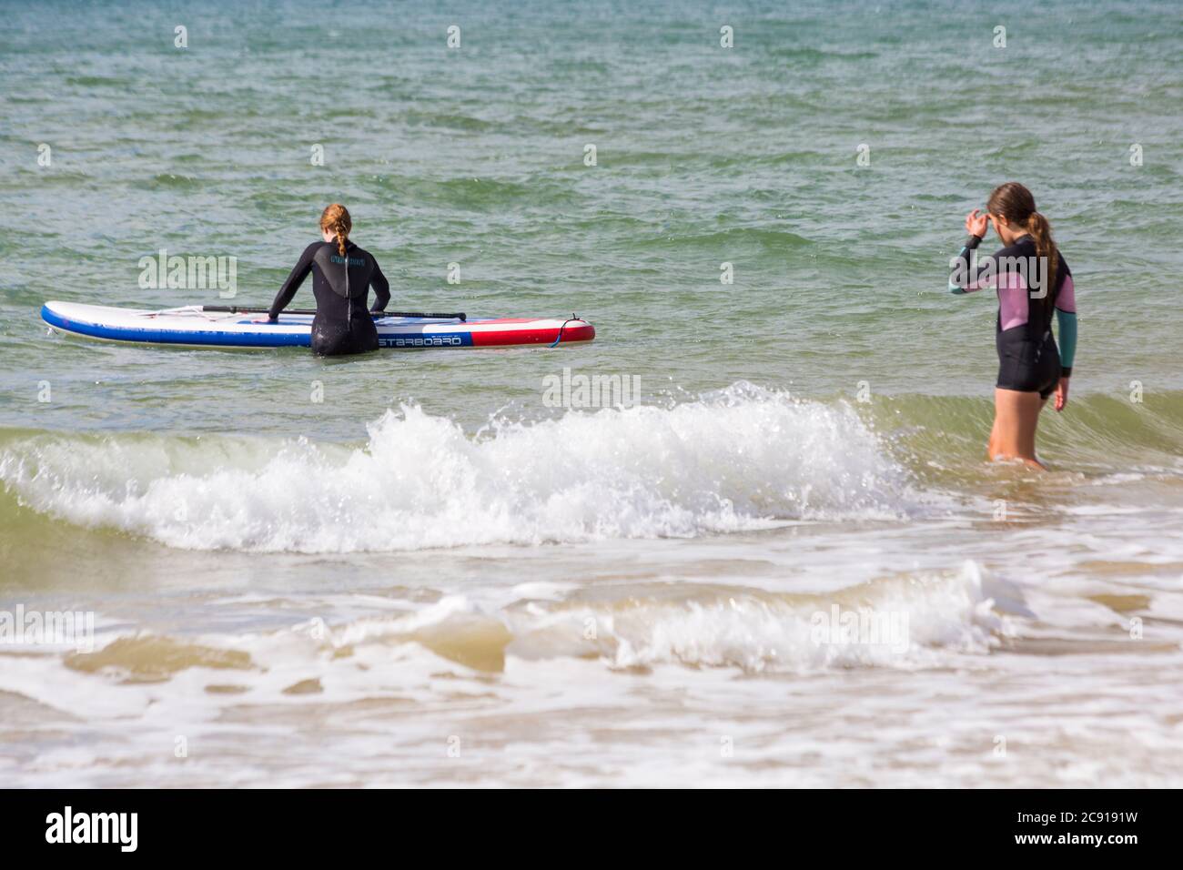 Paddelboarder Paddelboarder im Juli im Meer bei Branksome Dene Chine, Poole, Dorset, UK Stockfoto