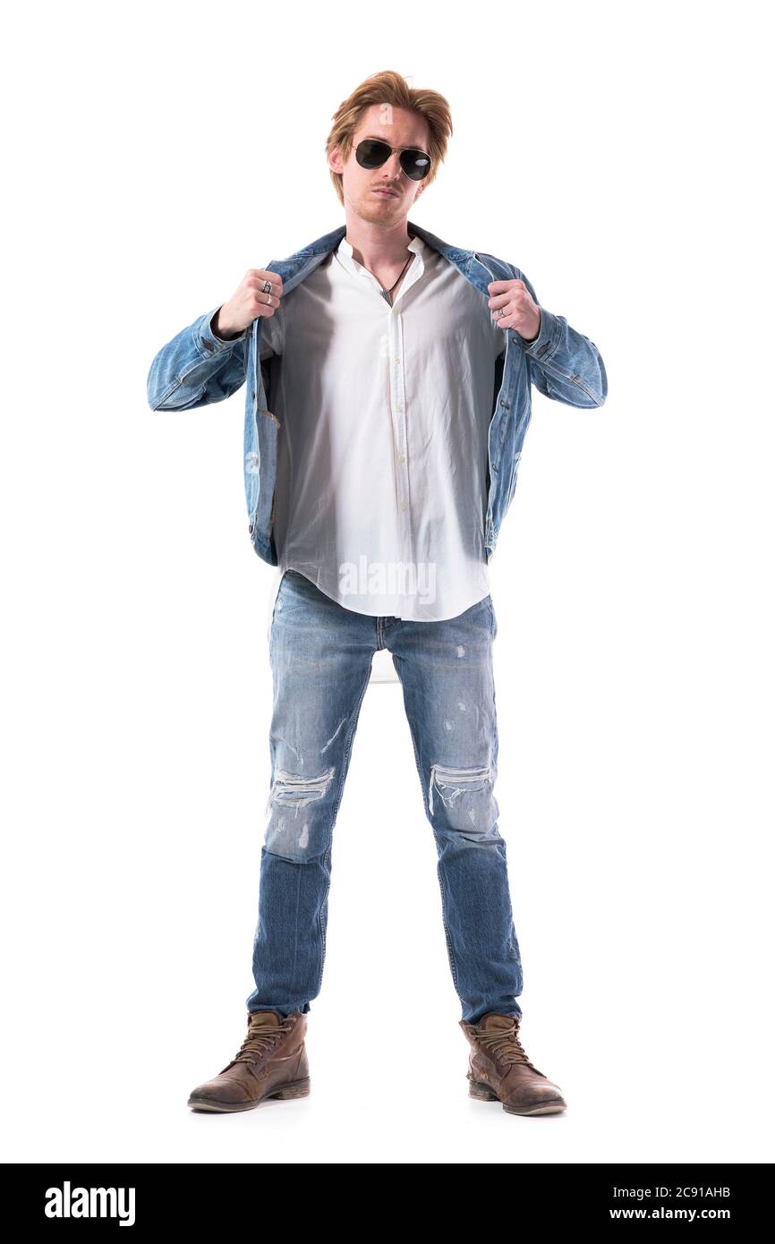 Selbstbewusster junger stilvoller Mann zieht Jean-Jacke in Denim an und zieht sich an. Ganzkörperlänge isoliert auf weißem Hintergrund. Stockfoto