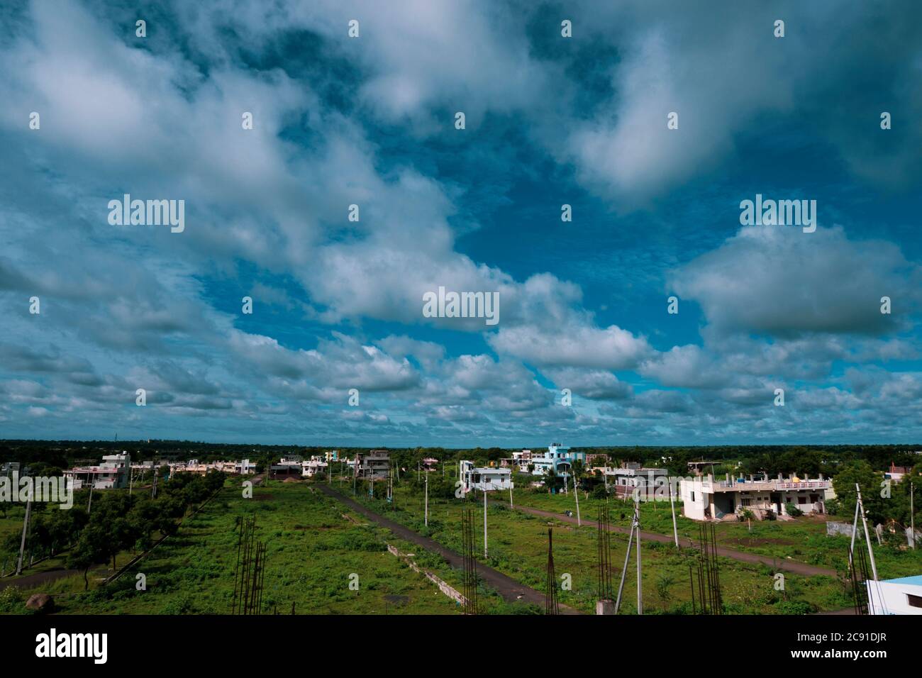 Ein langer Blick auf die Stadtlandschaft mit blauem Himmel, Wolken & grünem Land Stockfoto