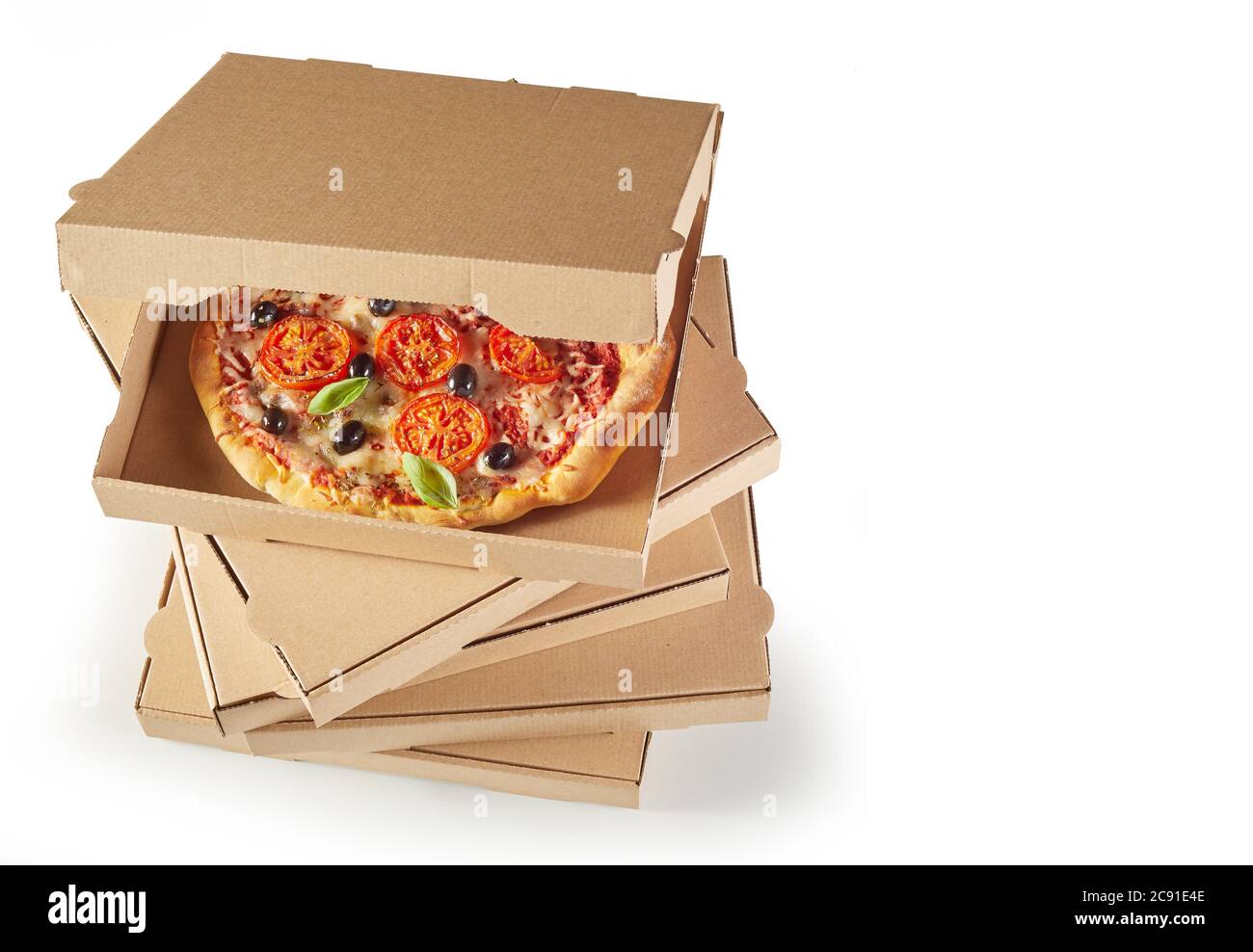 Frisch gebackene italienische Pizza in einer unbeschrifteten braunen Pappschachtel auf einem Stapel über Weiß mit Copyspace Stockfoto