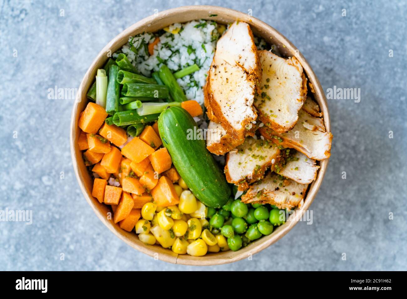 Take Away Healthy Organic Turkish Protein Bowl mit gerösteten Chicken Scheiben, Jasminreis, Gurke, Schnittlauch, grünen Erbsen, Karotten und Mayonnaise Joghurt S Stockfoto