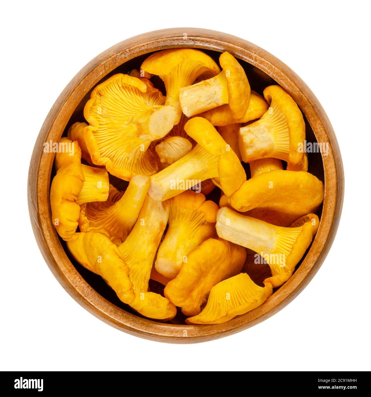 Frische Pfifferlinge in einer Holzschüssel. Cantharellus, beliebte essbare Pilze mit intensiver gelber Farbe. Einer der bekanntesten und geernteten Pilze. Stockfoto