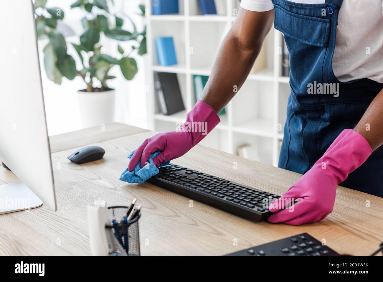 Beschnittene Ansicht der afroamerikanischen Reiniger in Gummihandschuhen  Reinigung Computer-Tastatur auf Bürotisch Stockfotografie - Alamy