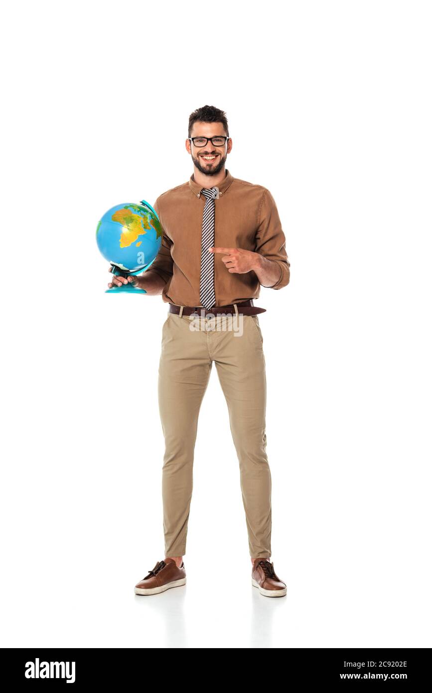 Schöner Lehrer zeigt mit dem Finger auf Globus und lächelt auf Kamera auf weißem Hintergrund Stockfoto