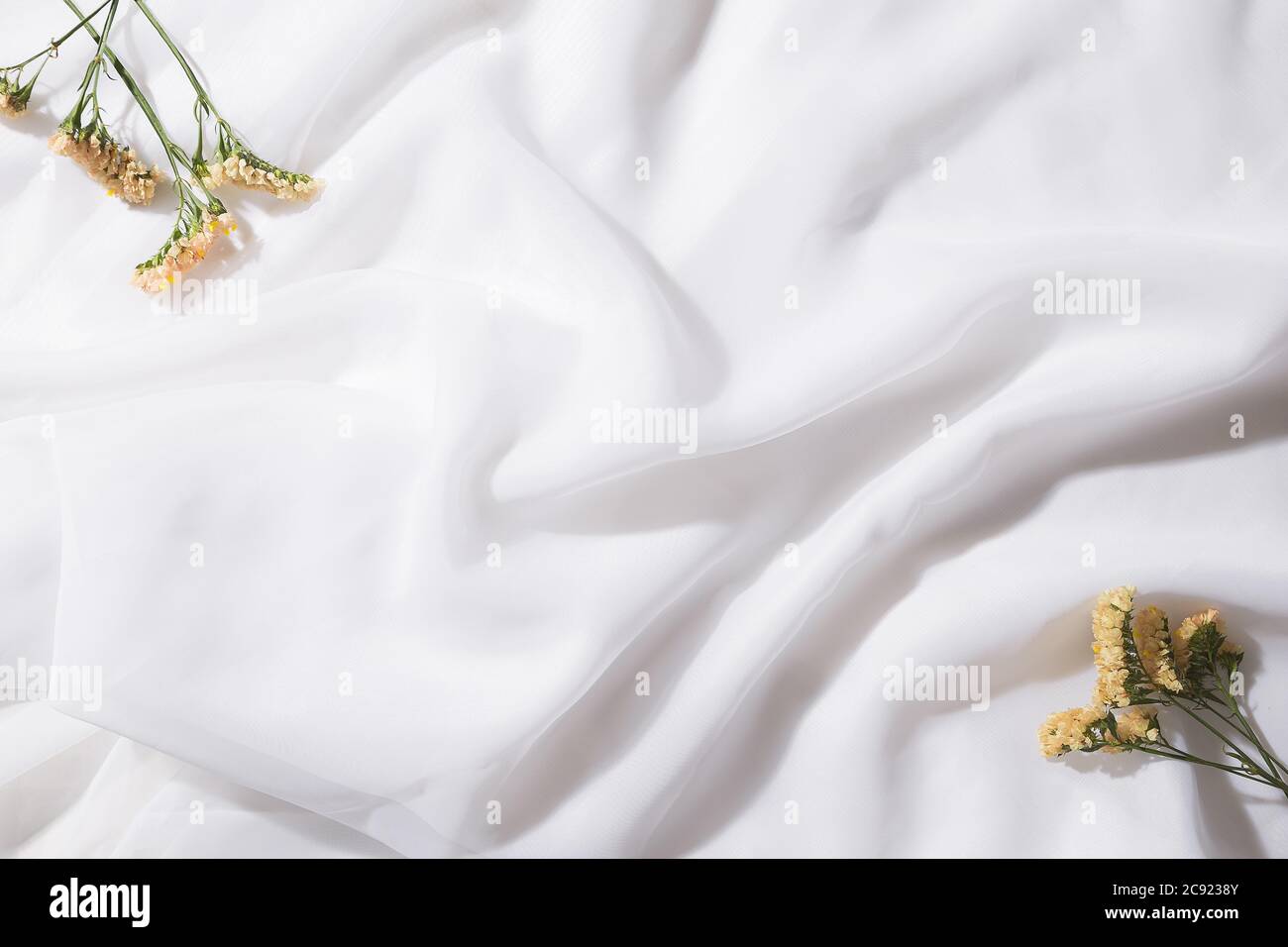 Draufsicht auf Voile Stoff Hintergrund mit Blumen in zwei Ecken mit Platz für Text Stockfoto