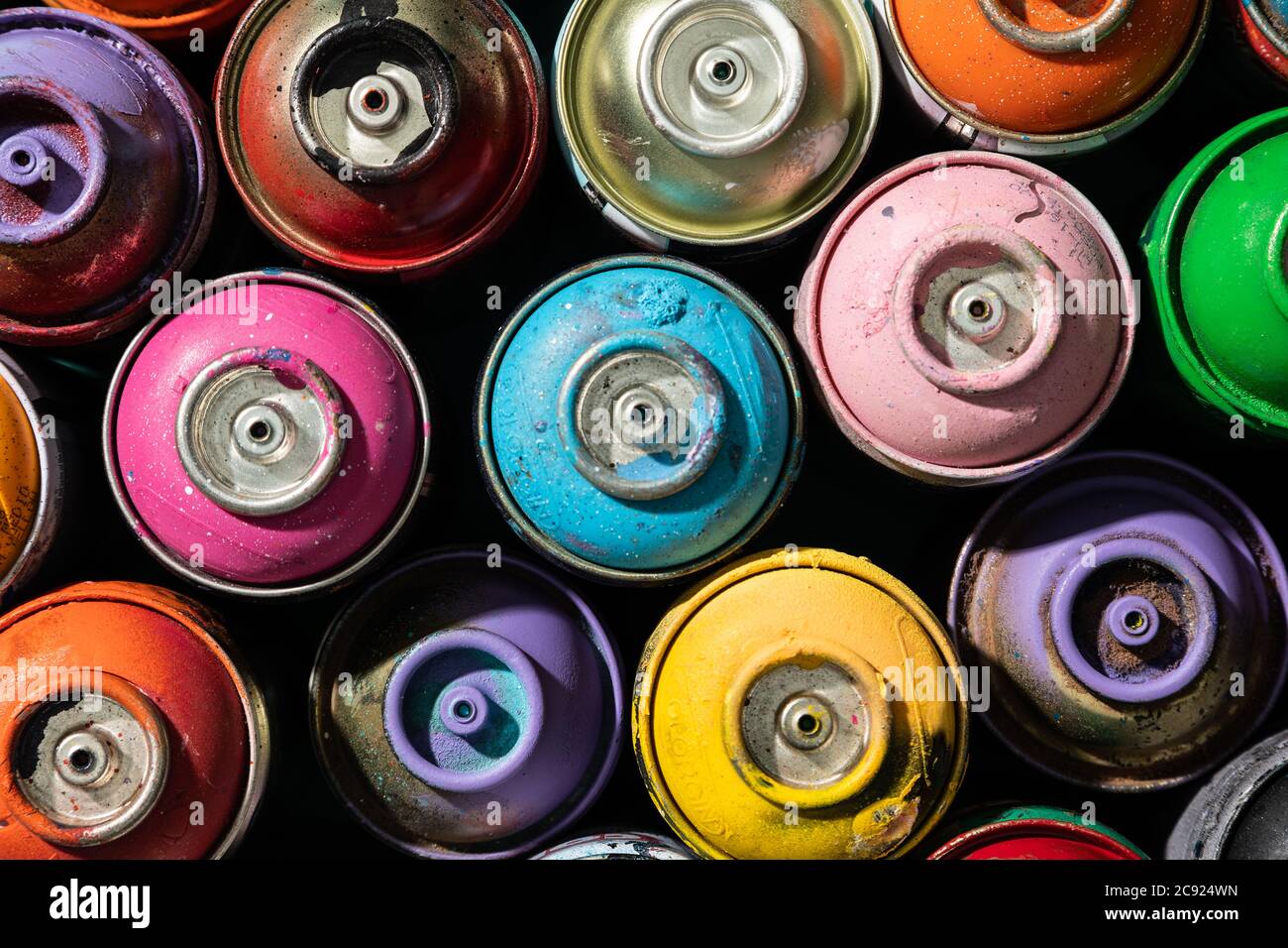 Draufsicht auf gebrauchte Spritzlackierdosen mit mehreren Farben Stockfoto