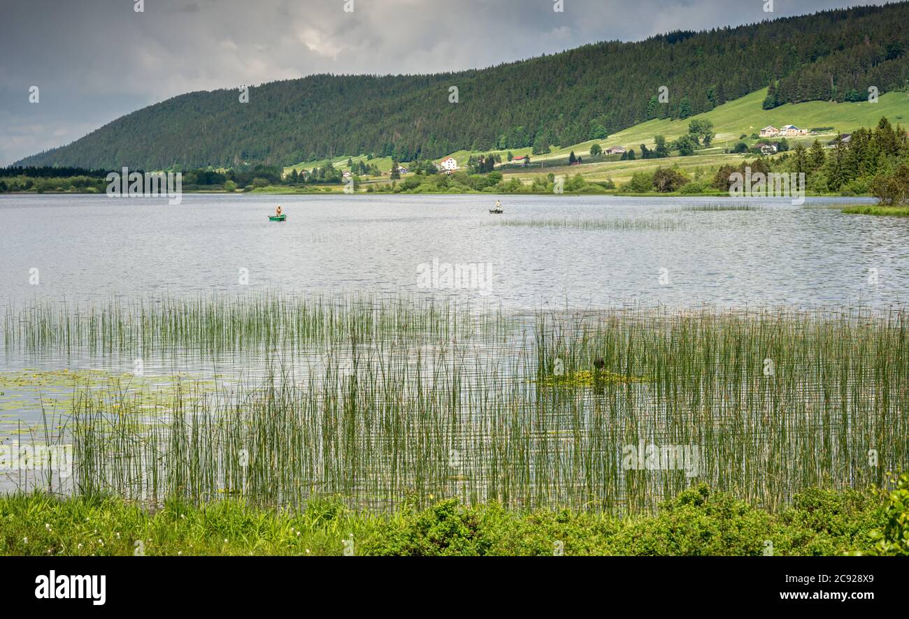 Der Rousses See mit Gras und Fischern Stockfoto