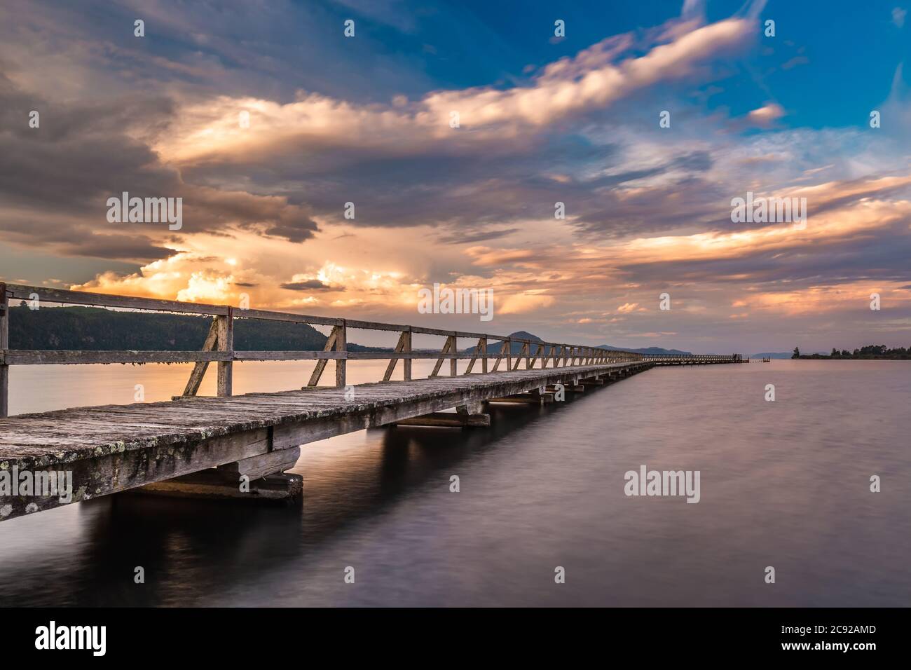 Alte hölzerne Werft mit langer Belichtung während des Sonnenuntergangs geschossen. Lage ist Tokaanu Wharf in Taupo Region North Island, Neuseeland. Stockfoto