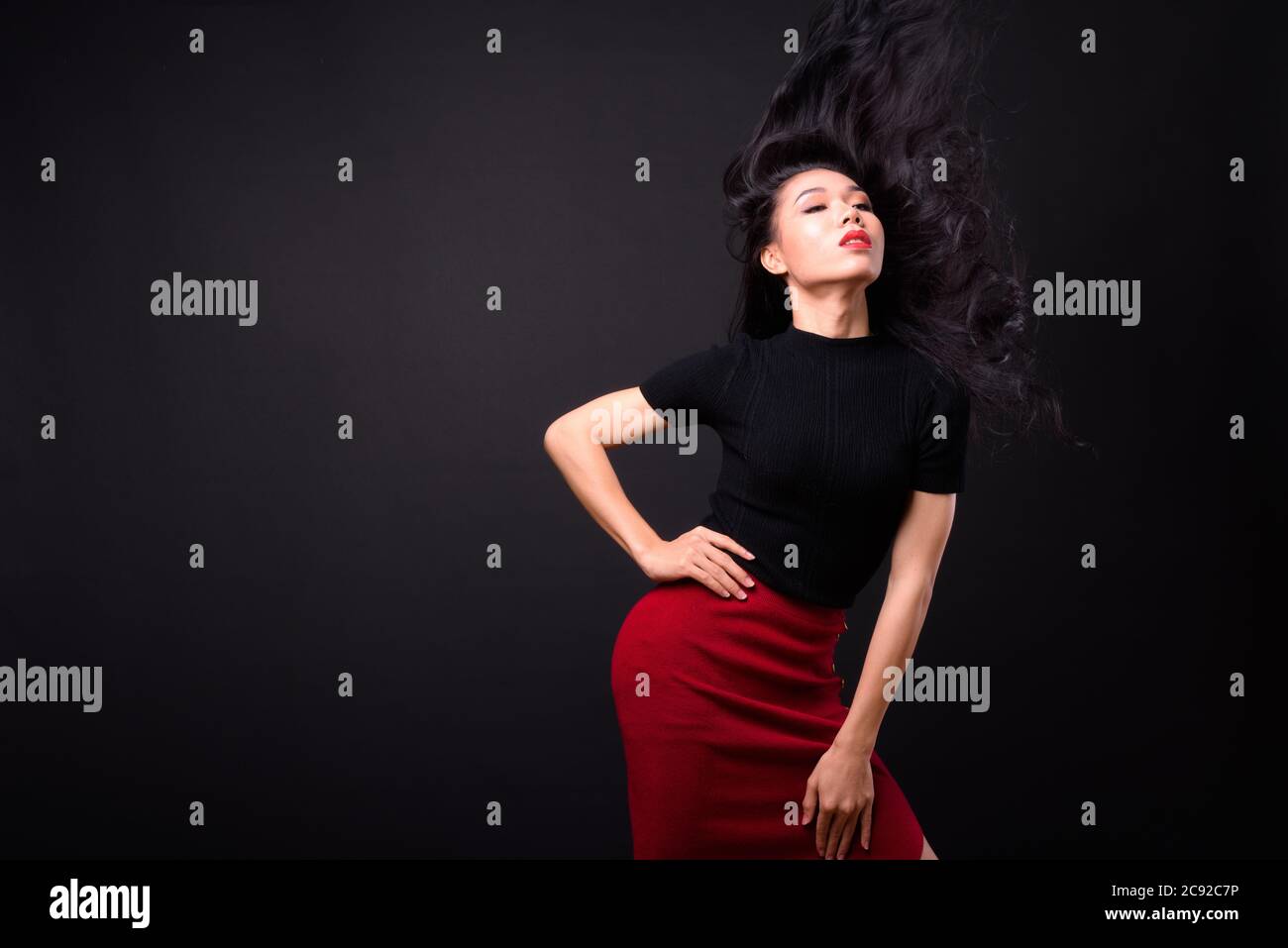 Junge schöne asiatische Transgender Geschäftsfrau vor schwarzem Hintergrund Stockfoto