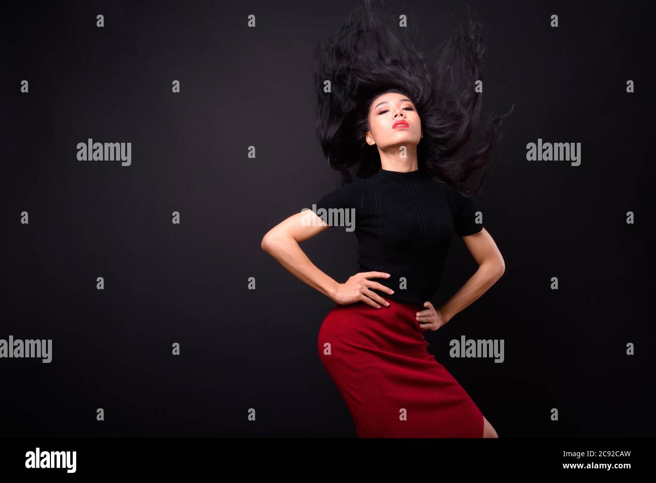 Junge schöne asiatische Transgender Geschäftsfrau vor schwarzem Hintergrund Stockfoto