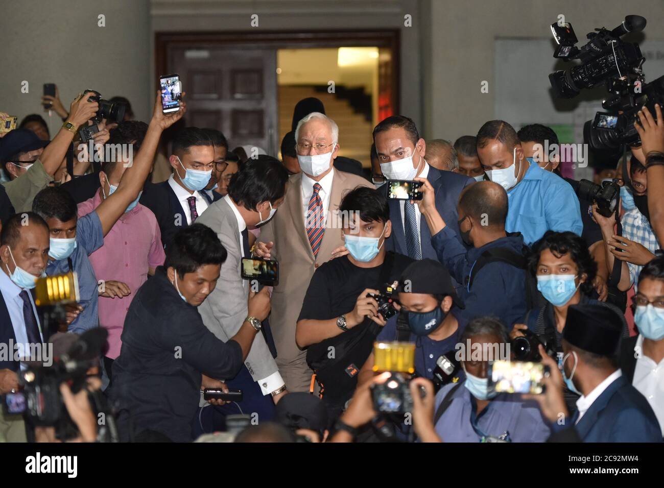 Kuala Lumpur, Malaysia. Juli 2020. Der ehemalige malaysische Premierminister Najib Razak (C) verlässt das Gericht in Kuala Lumpur, Malaysia, 28. Juli 2020. Der ehemalige malaysische Premierminister Najib Razak wurde am Dienstag in einem Fall im Zusammenhang mit SRC International, einer ehemaligen Einheit des staatlichen Investmentfonds 1Malaysia Development Berhad (1MDB), wegen Machtmissbrauchs, strafrechtlicher Vertrauensverletzung und Geldwäsche für schuldig befunden. Das Urteil ist das erste in mehreren Korruptionsverfahren gegen Najib. Quelle: Chong Voon Chung/Xinhua/Alamy Live News Stockfoto