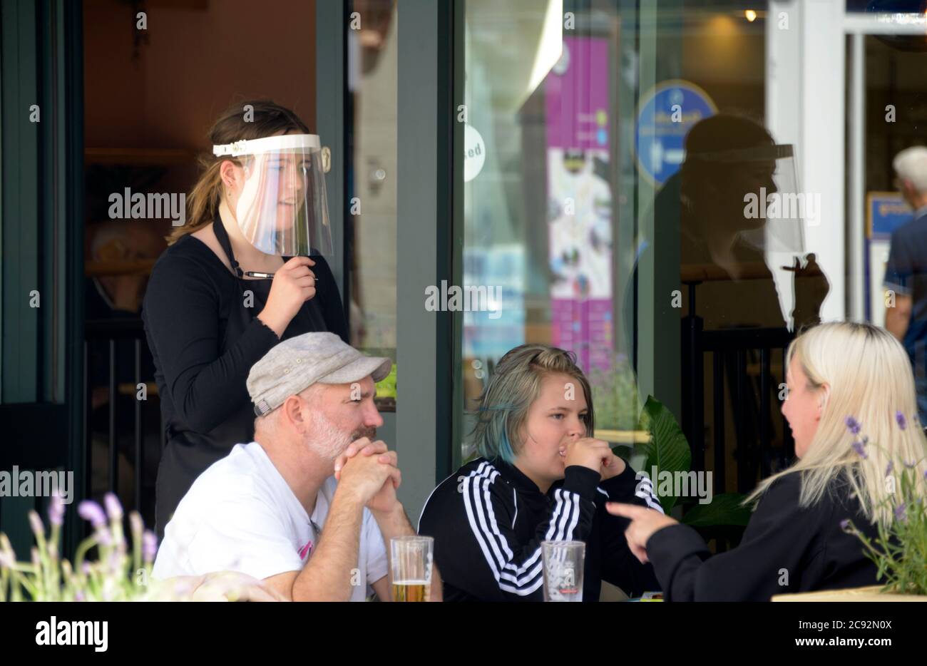 Menschen in einem Restaurant, nach der Sperre, Bestellung von Kellnerin, in einem Visier. Stockfoto