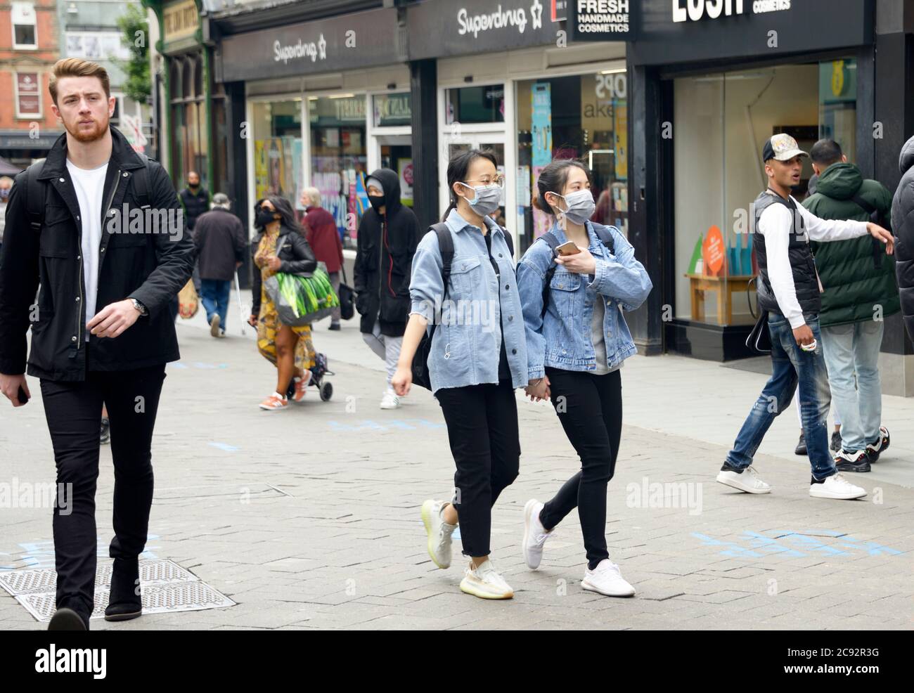 Orientalische Mädchen in Jeansjacken, mit Gesichtsmasken, Post-COVID 19 Lockdown, in Nottingham. Stockfoto