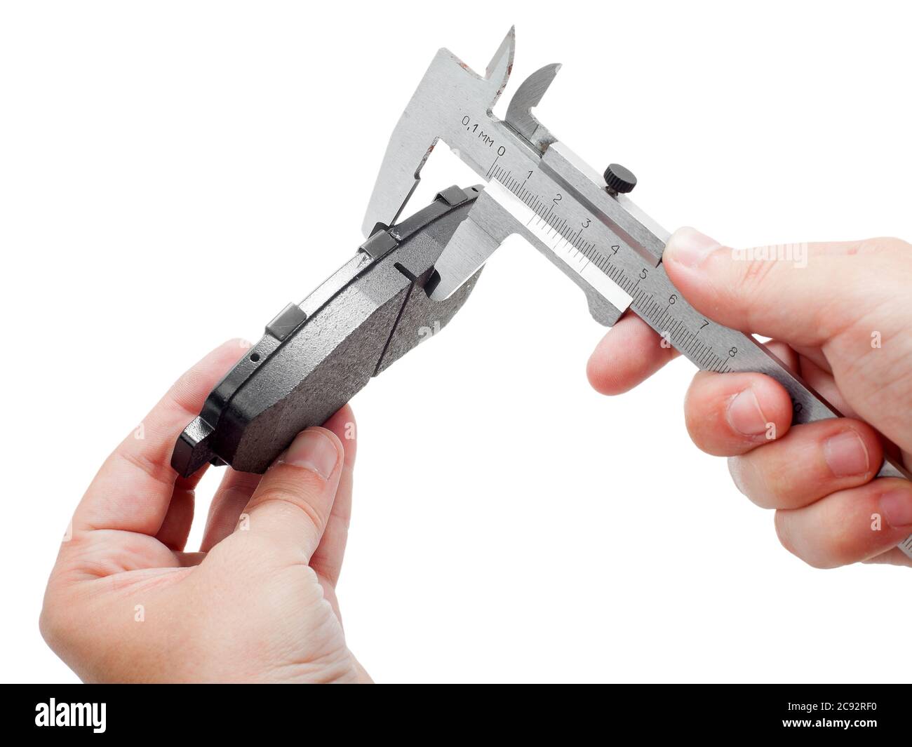 Bremsbeläge des Kfz-Ersatzteiles auf weißem Hintergrund, Messung durch einen Bremssattel der Dicke auf der Hand des Ingenieurs. Stockfoto