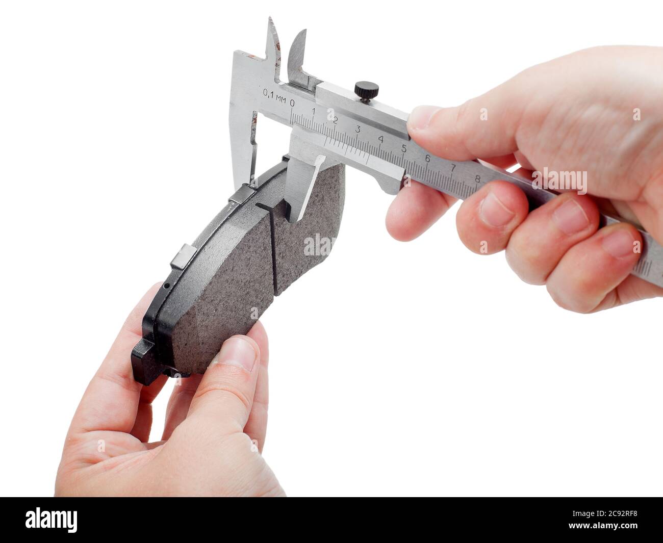 Bremsbeläge des Kfz-Ersatzteiles auf weißem Hintergrund, Messung durch einen Bremssattel der Dicke auf der Hand des Ingenieurs. Stockfoto