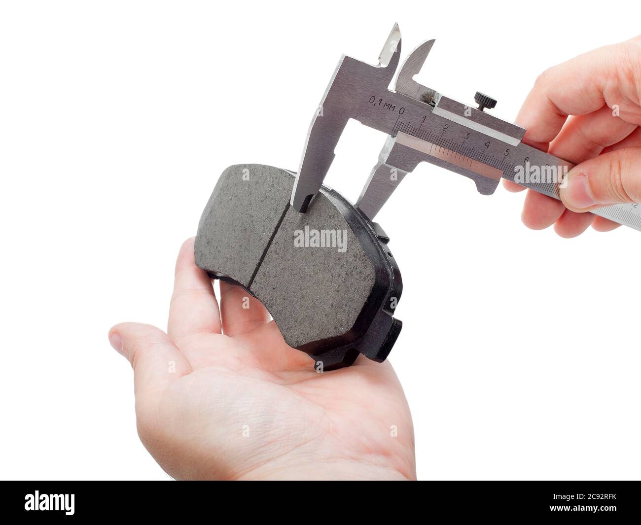 Bremsbeläge des Kfz-Ersatzteiles auf weißem Hintergrund, Messung durch einen Bremssattel der Dicke auf der Hand des Ingenieurs. Stockfoto