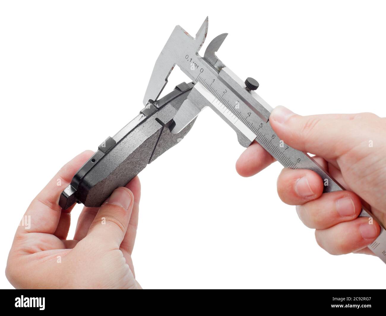 Bremsbeläge des Kfz-Ersatzteiles auf weißem Hintergrund, Messung durch einen Bremssattel der Dicke auf der Hand des Ingenieurs. Stockfoto