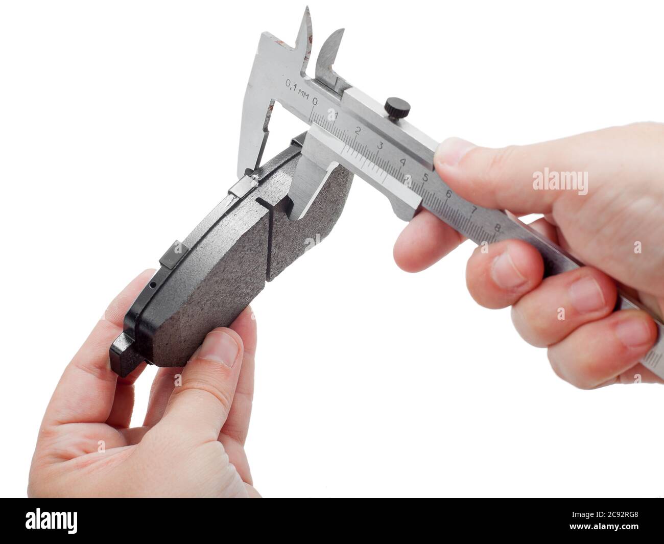 Bremsbeläge des Kfz-Ersatzteiles auf weißem Hintergrund, Messung durch einen Bremssattel der Dicke auf der Hand des Ingenieurs. Stockfoto