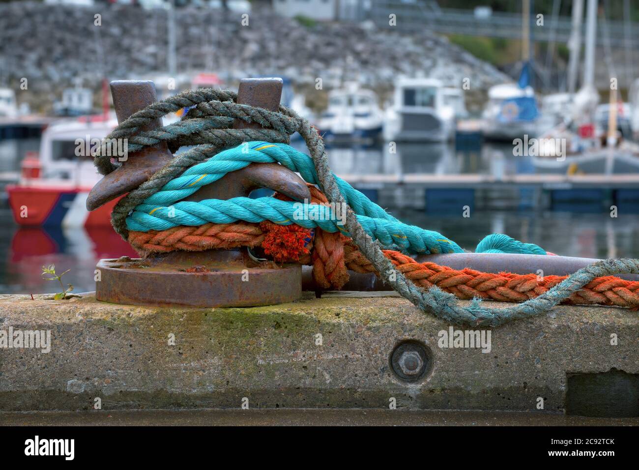 Ein Ankerplatz Poller mit Farbseilen oder Falschmacherei. Mallaig Harbour, Schottland Stockfoto