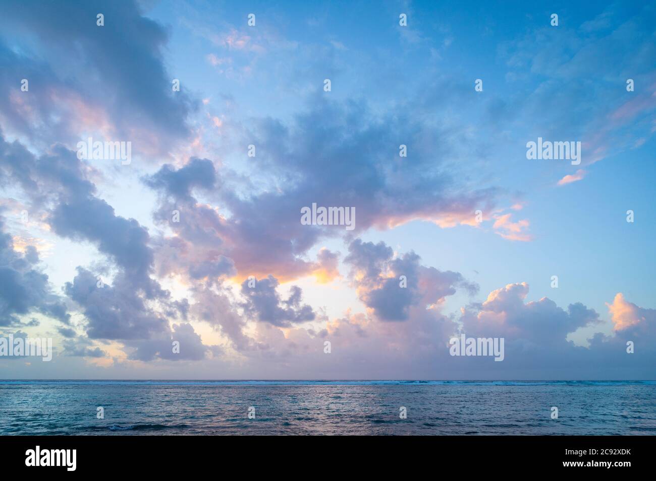 Wunderschöne rosa und orange Wolken bei Sonnenaufgang über der Karibik, Grand Cayman Island Stockfoto