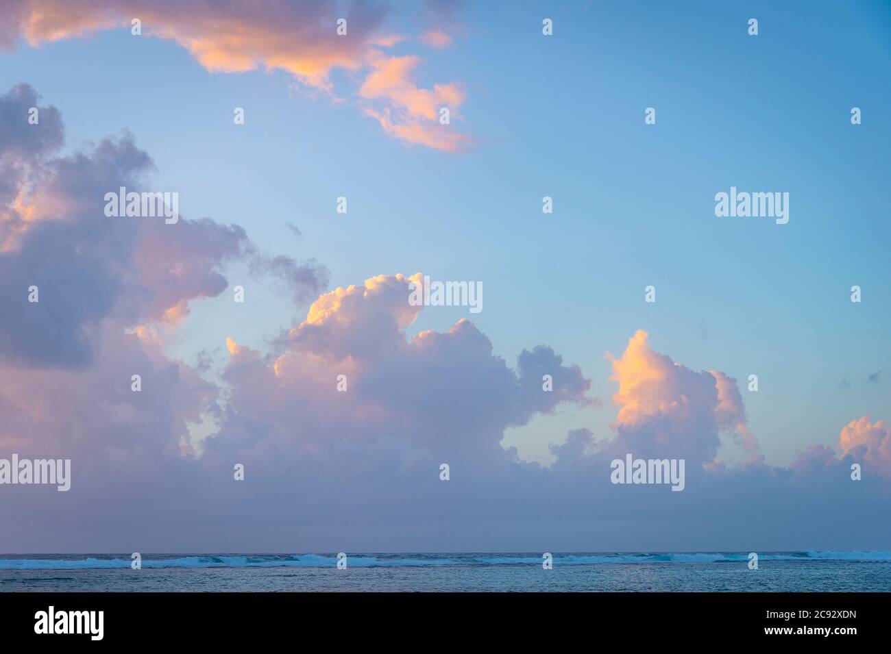 Wunderschöne rosa und orange Wolken bei Sonnenaufgang über der Karibik, Grand Cayman Island Stockfoto