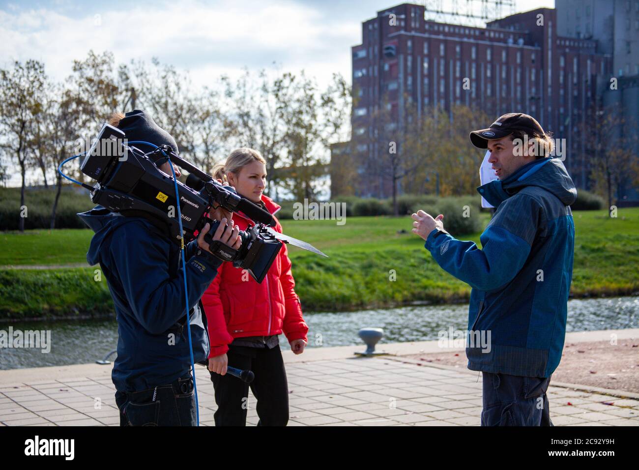 MONTREAL, KANADA - 16. Okt 2010: Montreal, Quebec / Kanada - 16 2010. Okt: Reporter in roter Kleidung und Kameramann mit seiner Panasonic Shoulder Cam Stockfoto