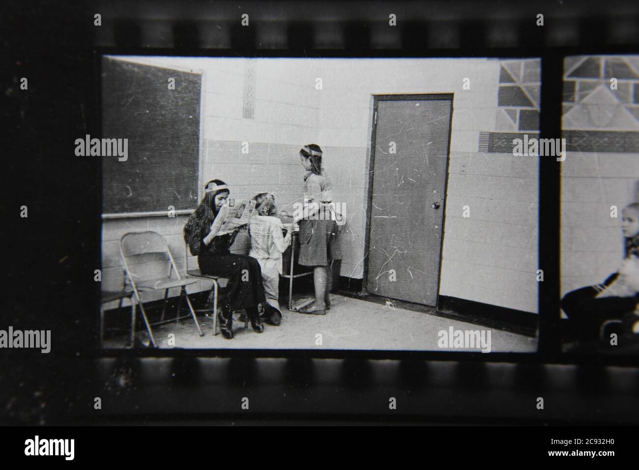 Feine Vintage-Schwarz-Weiß-Fotografie der 1970er Jahre von Kindern, die im Klassenzimmer herumhängen. Stockfoto
