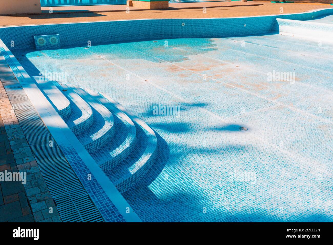 Blauer alter Pool, trocken und schmutzig am Boden. Speicherplatz kopieren. Konzept der Wartung und Reinigung von Schwimmbädern. Stockfoto