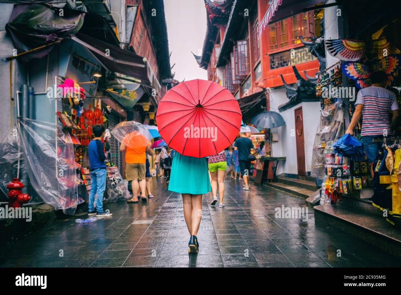 Menschen Frau, die in chinatown Einkaufsstraße läuft. Regentag Mädchen Tourist unter roten orientalischen Regenschirm in engen Gassen auf china reisen in Shanghai Stockfoto