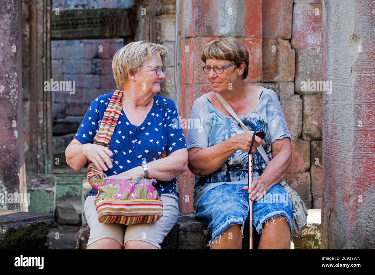 Zwei ältere westliche Touristen ruhen im Tempelkomplex Angkor Wat aus dem 12. Jahrhundert, der dem gott Vishnu, Siem Reap, Kambodscha, Asien gewidmet ist Stockfoto